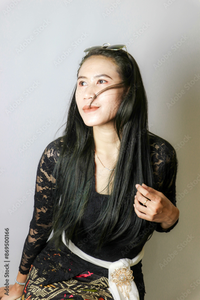 portrait of an Indonesian woman wearing a black kebaya in the studio with a disheveled pose isolated white background portrait of an Indonesian woman wearing a black kebaya in the studio with a disheveled pose isolated white background