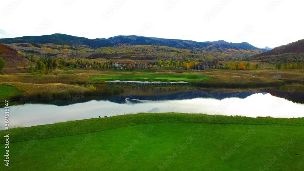 Aerial: Drone Panning Shot Of Birds Swimming In Lake On Green Landscape By Mountains Against Clear Sky - Aspen, Colorado Aerial: Drone Panning Shot Of Birds Swimming In Lake On Green Landscape By Mountains Against Clear Sky - Aspen, Colorado