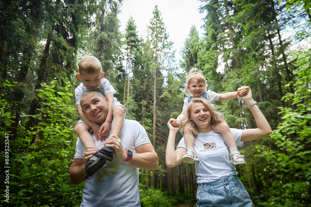 Fototapeta premium A man, woman, and child having fun and playing in the forest or park in summer or spring sunny day