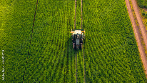Foto Aerial shot farmer rides a tractor with an organic fertilizer spreader to increase productivity and fertilize his fields