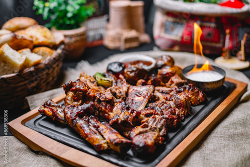 side view meat kebab with grilled potatoes and vegetables with sauce and fire on a board