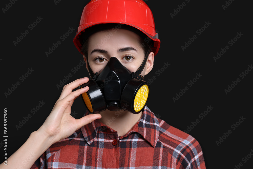 Woman in respirator and helmet on black background Woman in respirator and helmet on black background