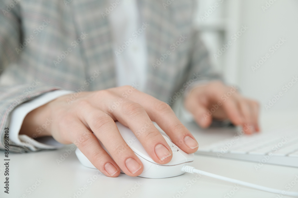Woman working with wired mouse and computer keyboard at white table indoors, closeup Woman working with wired mouse and computer keyboard at white table indoors, closeup