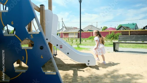 4k footage of funny toddler girl climbing on wooden stapladder on children playground at park photo