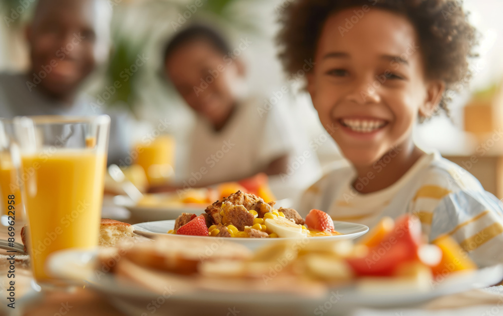 A smiling child enjoying a delicious breakfast with family at home, featuring fresh fruits, juice, and various dishes on a sunny morning. A smiling child enjoying a delicious breakfast with family at home, featuring fresh fruits, juice, and various dishes on a sunny morning.