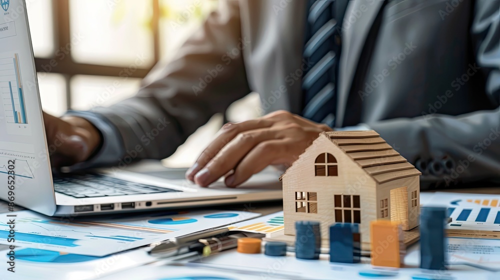 Fototapeta premium Businessman Analyzing Real Estate Finance Data and Digital Models on Laptop in Sophisticated Office