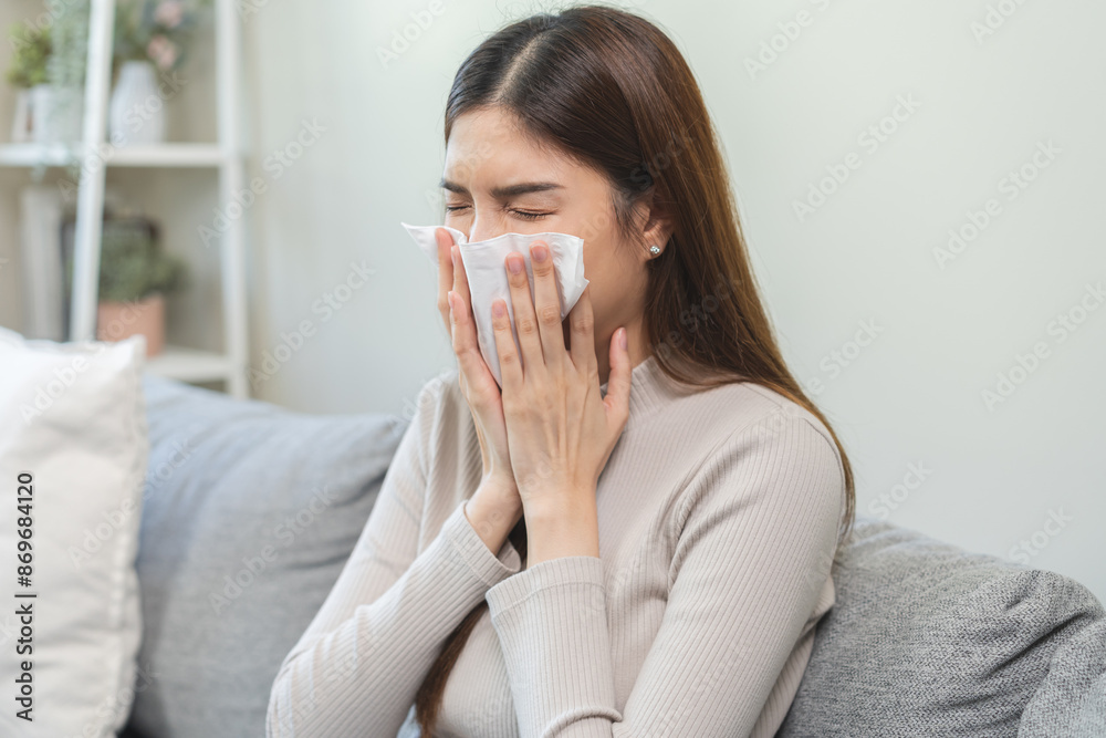 Sick, coronavirus or covid, tired asian young woman have a fever, flu and hand in use tissues paper sneezing nose, runny while sitting on sofa, couch at home. Health care with disease, pandemic virus Sick, coronavirus or covid, tired asian young woman have a fever, flu and hand in use tissues paper sneezing nose, runny while sitting on sofa, couch at home. Health care with disease, pandemic virus
