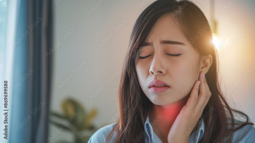 Fototapeta premium Sickness in inflaming asian young woman, girl use hand check self touch at sore throat, pain thyroid gland on neck or disease reflux, acid of suffer people on wall background. Medical and healthcare