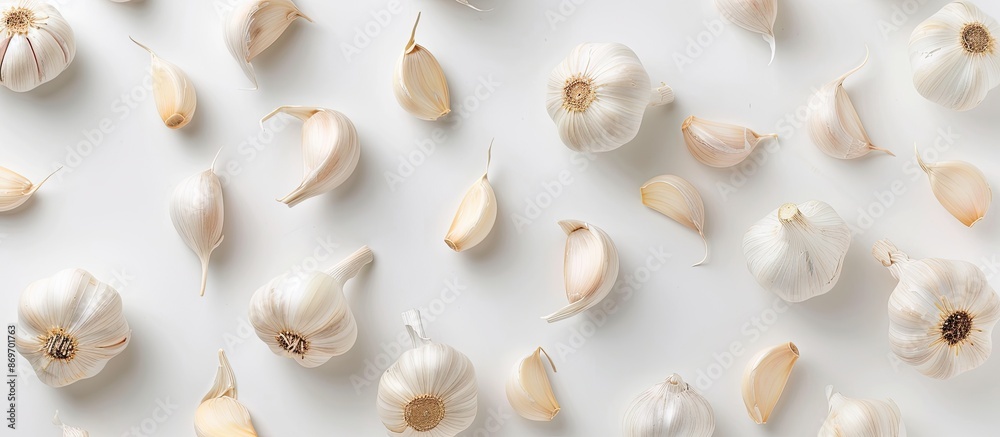 Many garlic cloves are arranged on a white background, creating a visually appealing copy space image. Many garlic cloves are arranged on a white background, creating a visually appealing copy space image.