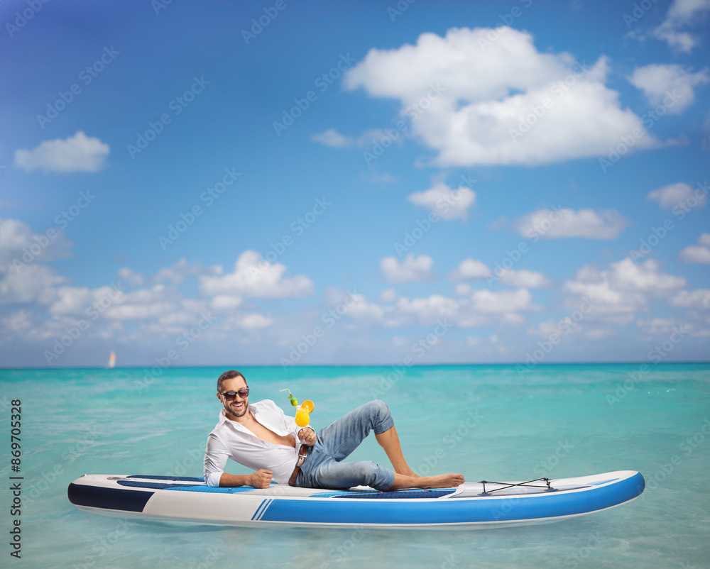 Fototapeta premium Guy sitting on a SUP in the sea