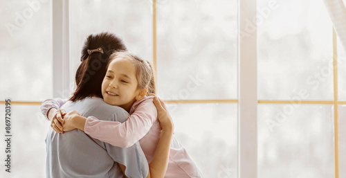 Foto A young girl is hugging her mother from behind