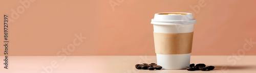 A takeaway coffee cup with a latte against a peach background, surrounded by coffee beans. Perfect for cafe or coffee shop promotions. photo