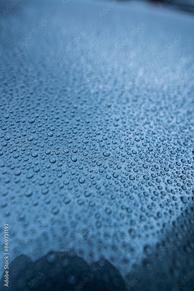 Perfect round water drops on blue car body. Hydrophobic effect after use car ceramic coating