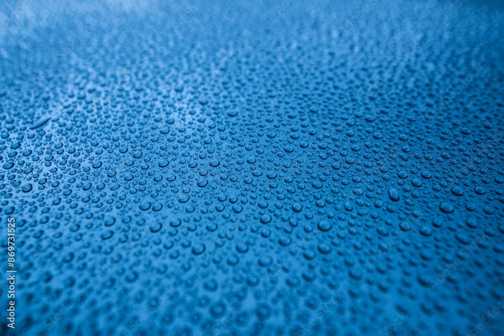 Perfect round water drops on blue car body. Hydrophobic effect after use car ceramic coating