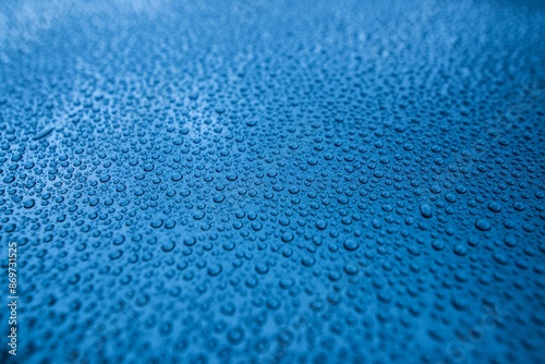 Perfect round water drops on blue car body. Hydrophobic effect after use car ceramic coating