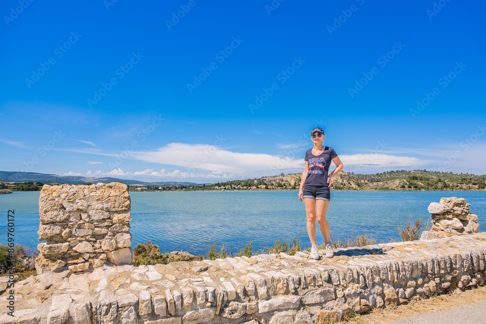 Femme en randonnée sur la Promenade des pontons dans la Saline de Peyriac-de-Mer Femme en randonnée sur la Promenade des pontons dans la Saline de Peyriac-de-Mer