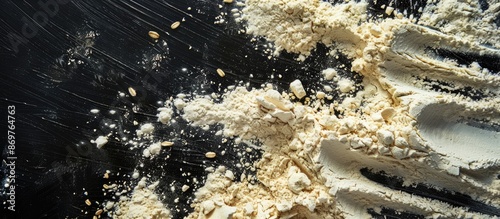 Top view of scattered wheat flour splashes on a black background, creating a baking-themed copy space image. photo