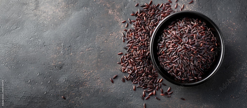 A bowl containing dark, long-grain black rice with copy space image. A bowl containing dark, long-grain black rice with copy space image.