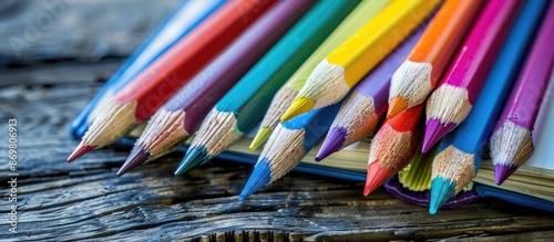 Top-down view of a variety of colored pencils placed on a book with a school theme. Ample space available for additional content in the image. photo