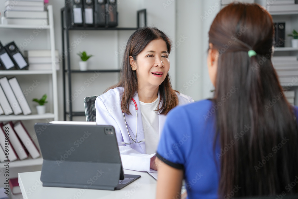 Asian female doctor smiling and talking with patient in doctor's office Asian female doctor smiling and talking with patient in doctor's office