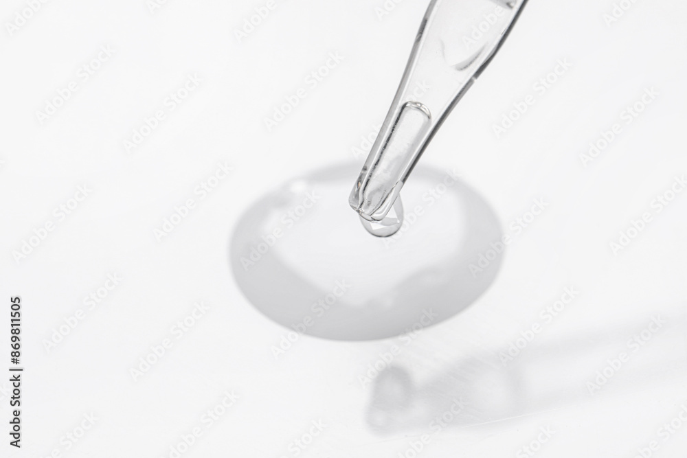 Glass pipette and transparent liquid on white background, closeup