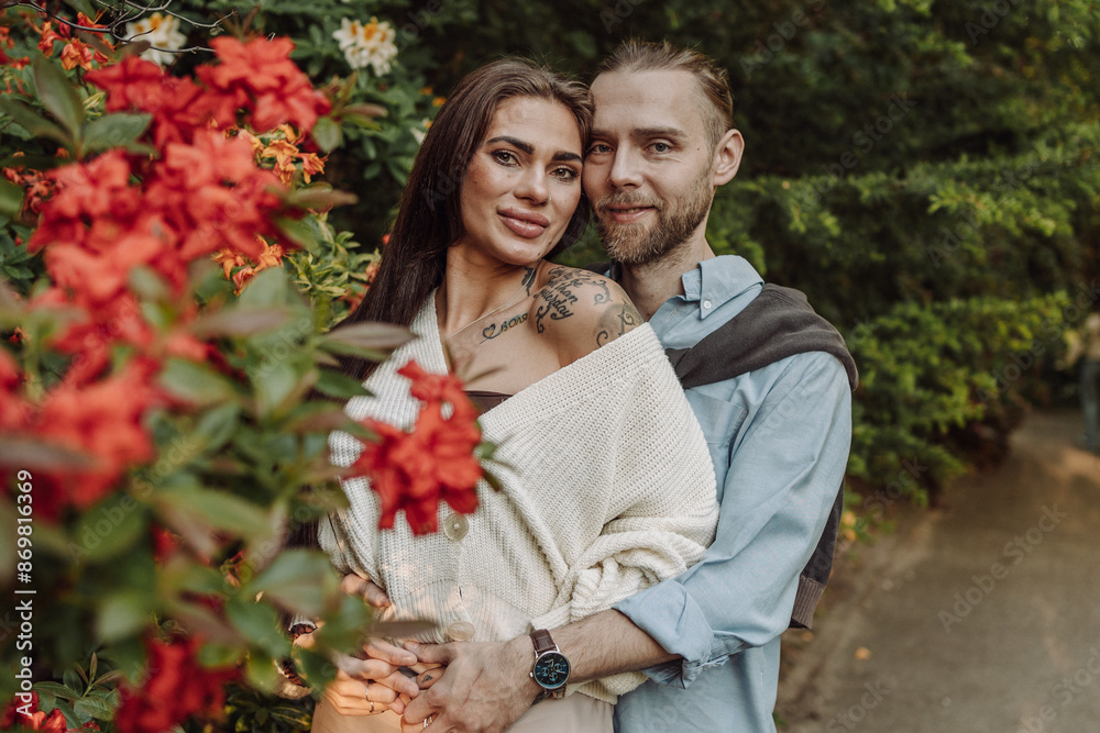 Obraz premium Young fun surprised couple family man woman in rest relax together boyfriend meet girlfriend. Close-up portrait of a girl with a freckled face standing and hugging his neck in the sunlight.