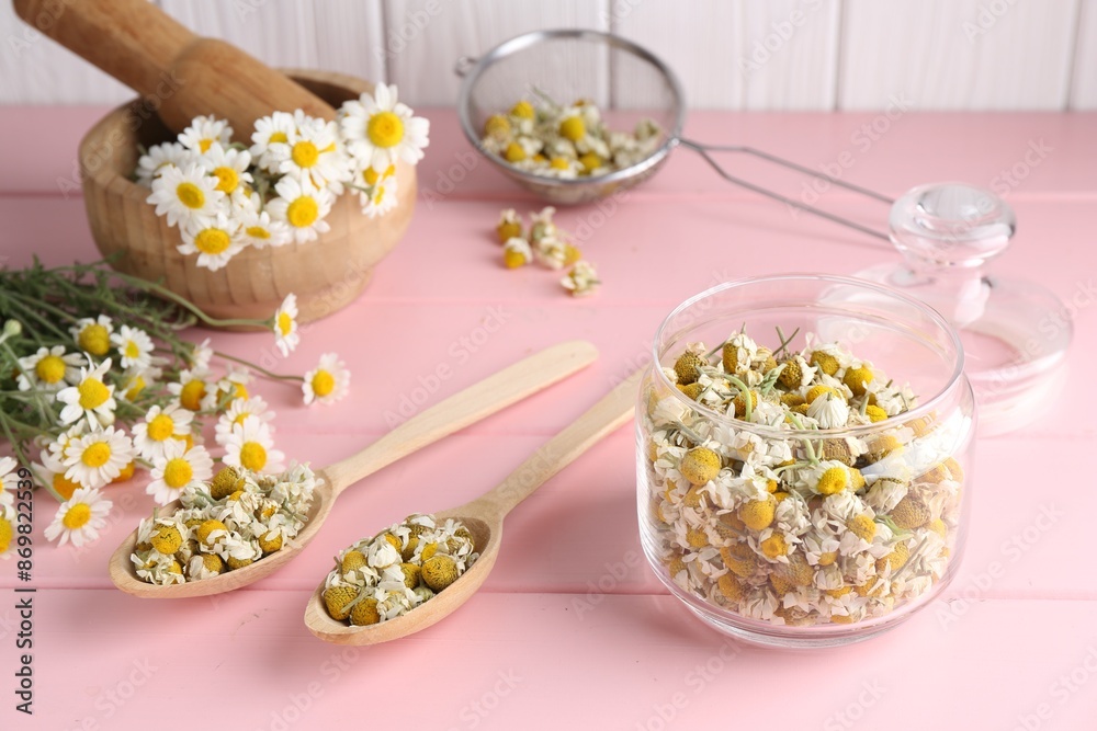 Dry and fresh chamomile flowers in dishware on pink wooden table Dry and fresh chamomile flowers in dishware on pink wooden table