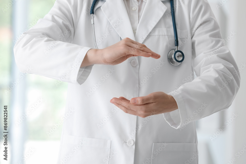 Doctor with stethoscope holding something in clinic, closeup Doctor with stethoscope holding something in clinic, closeup
