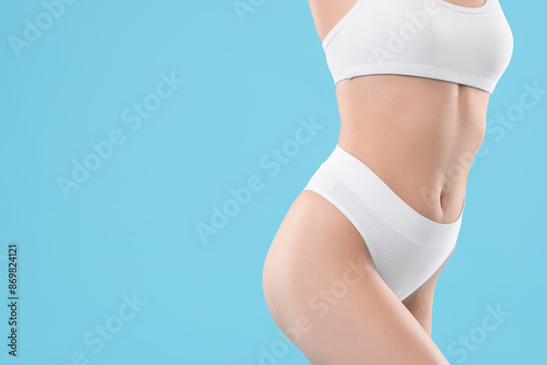 Diet and weight loss concept. Woman with slim body against light blue background, closeup. Space for text