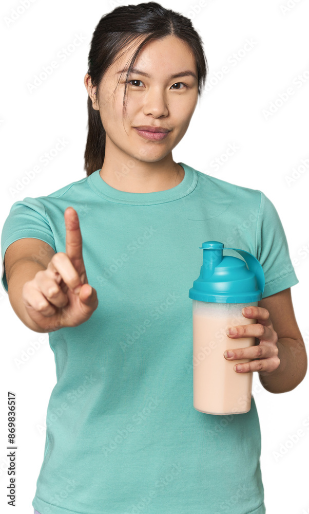 Chinese athlete with protein shake showing number one with finger. Chinese athlete with protein shake showing number one with finger.