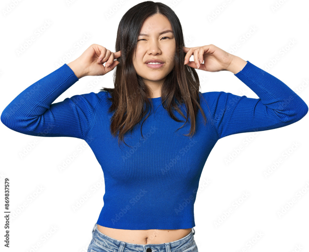 Young Chinese woman covering ears with fingers, stressed and desperate by a loudly ambient. Young Chinese woman covering ears with fingers, stressed and desperate by a loudly ambient.