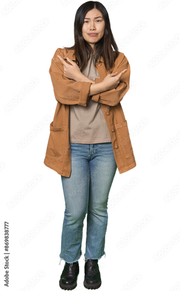 Fototapeta premium Full-body young Chinese woman points sideways, is trying to choose between two options.
