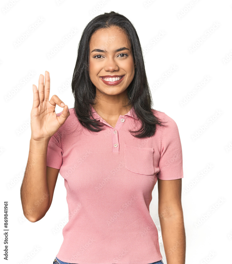 Simple portrait of a young Latina cheerful and confident showing ok gesture. Simple portrait of a young Latina cheerful and confident showing ok gesture.