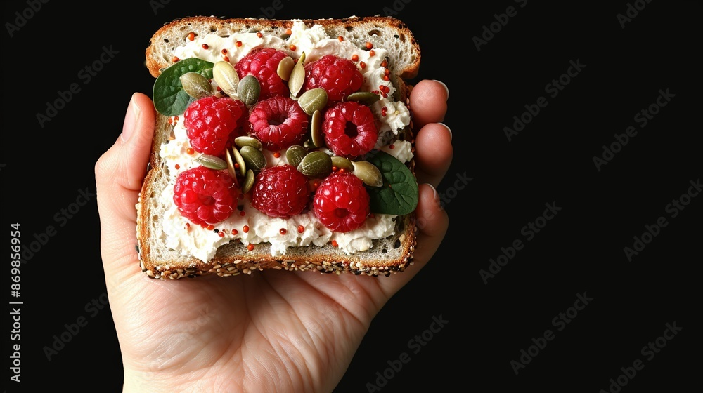 Close-up of a person holding bread with raspberries and pistachios Close-up of a person holding bread with raspberries and pistachios