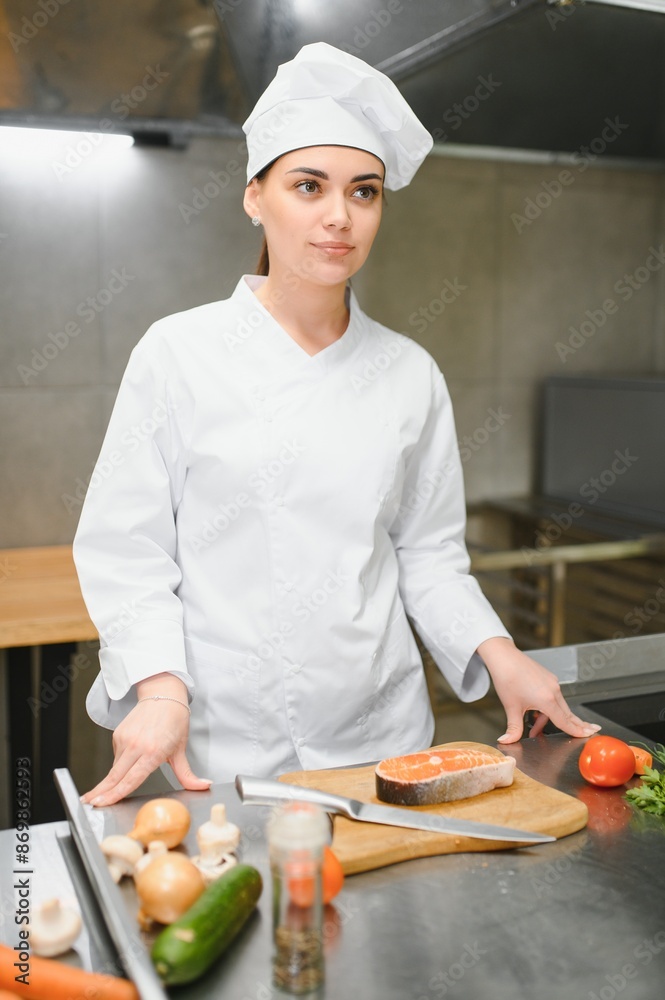 young beautiful female chef in kitchen young beautiful female chef in kitchen