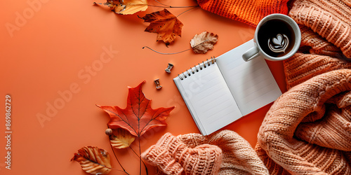 cup of coffee, an open notebook, warm sweater on orange background with scattered autumn leaves. For seasonal promotions, lifestyle blogs, and autumn themed projects