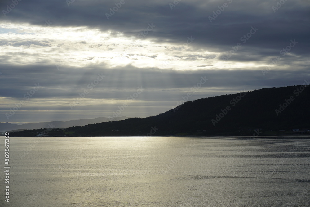 Summer in the fjords of Norway. A bright sunset and cirrus clouds illuminated by the setting sun. HDR light Summer in the fjords of Norway. A bright sunset and cirrus clouds illuminated by the setting sun. HDR light