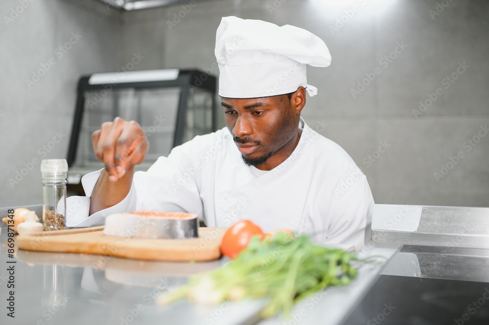 Portrait of happy African American male chef standing in restaurant kitchen Portrait of happy African American male chef standing in restaurant kitchen
