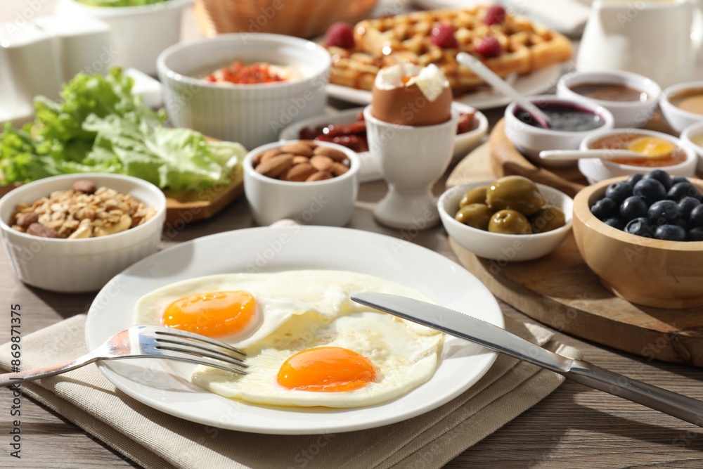 Different meals served for breakfast on wooden table Different meals served for breakfast on wooden table