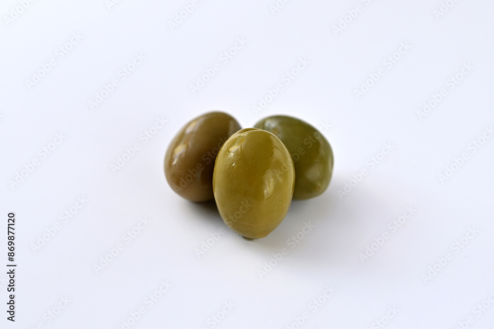 green olives on a white background close-up green olives on a white background close-up