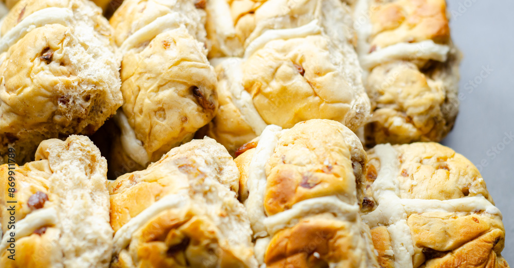 A tray of pastries with a white cross on top A tray of pastries with a white cross on top