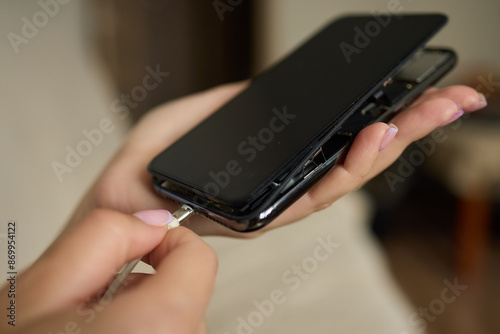 The image shows a closeup of someone gripping a lightning cable that appears to be damaged