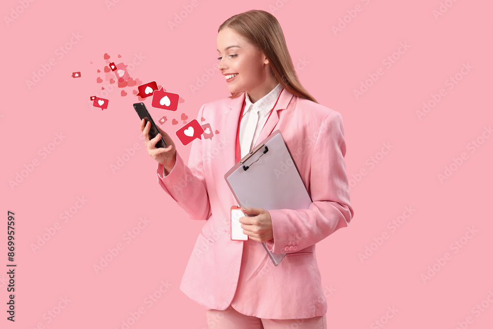 Young businesswoman with clipboard using mobile phone on pink background Young businesswoman with clipboard using mobile phone on pink background