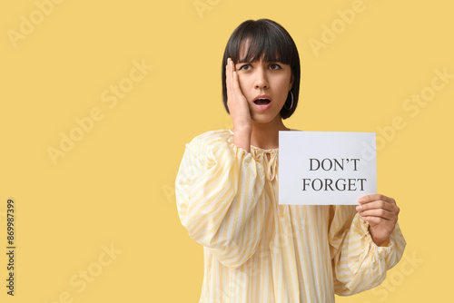 Surprised young woman holdi...