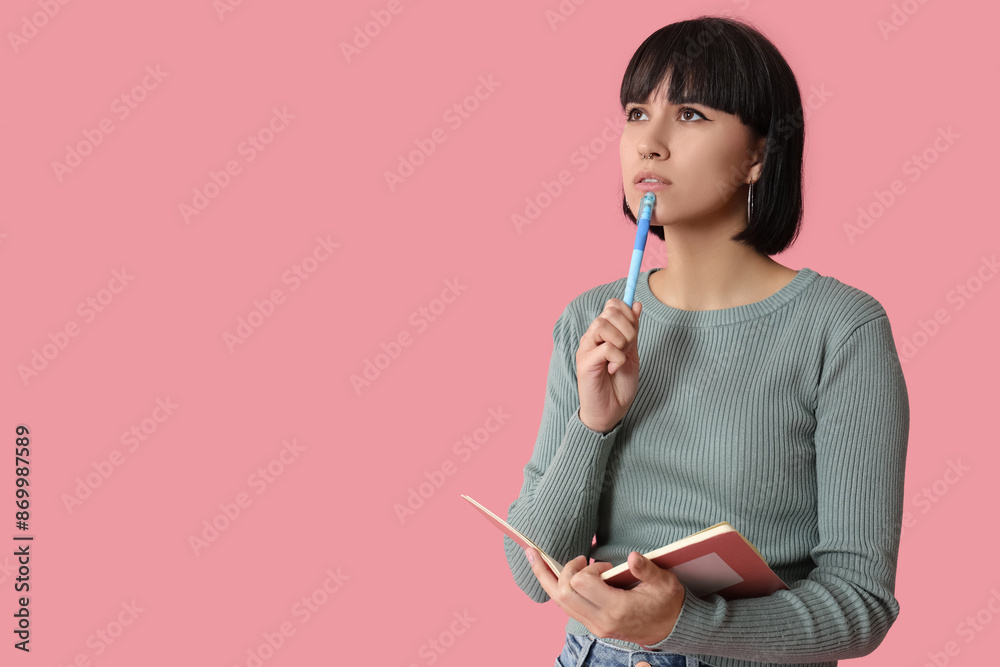 Pensive young woman with notebook trying to remember something on pink background Pensive young woman with notebook trying to remember something on pink background
