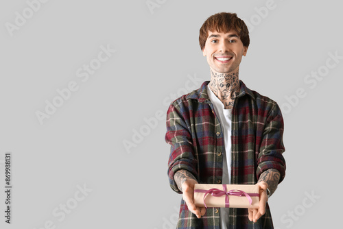Young tattooed man with gif...