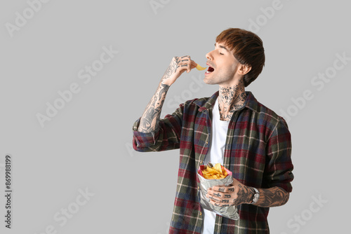 Young tattooed man eating p...