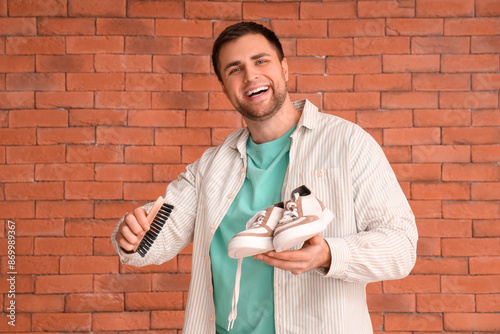 Male shoemaker with brush a...