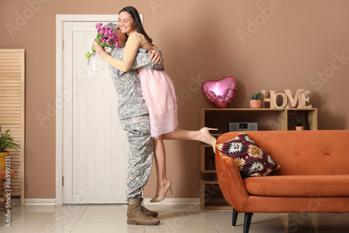 Man in military uniform hug...