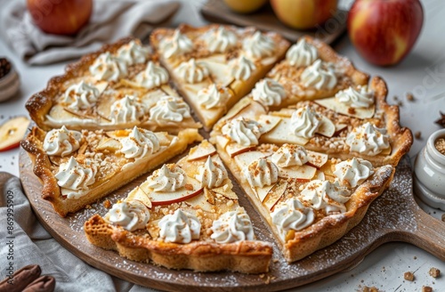 A Sliced Apple Tart With Whipped Cream and Powdered Sugar on a Wooden Board